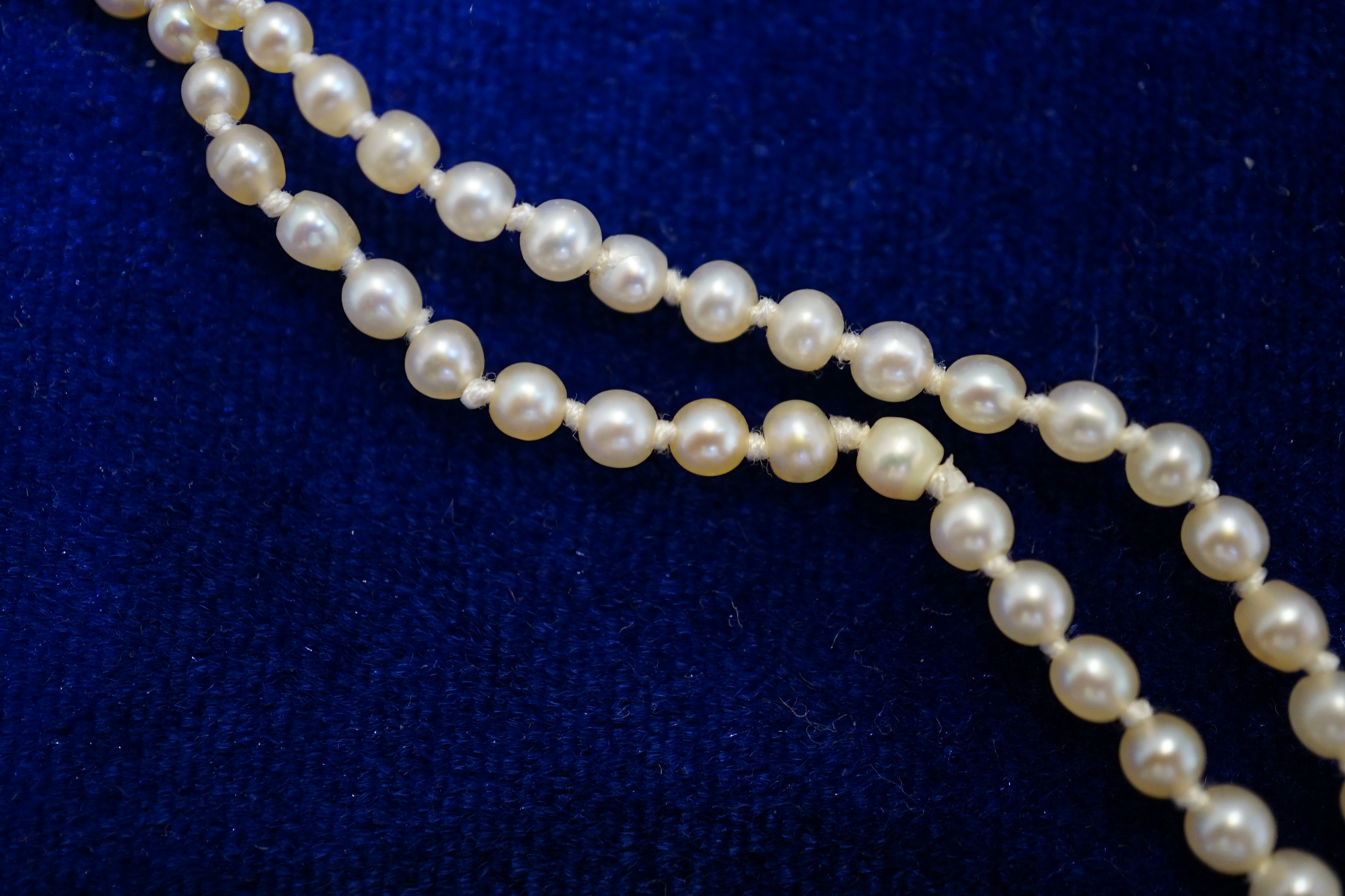 An early 20th century single strand graduated natural pearl and seed pearl necklace, with three stone diamond set clasp and Anchor Cert report dated 27/6/2014 stating an extensive sample to be natural pearls